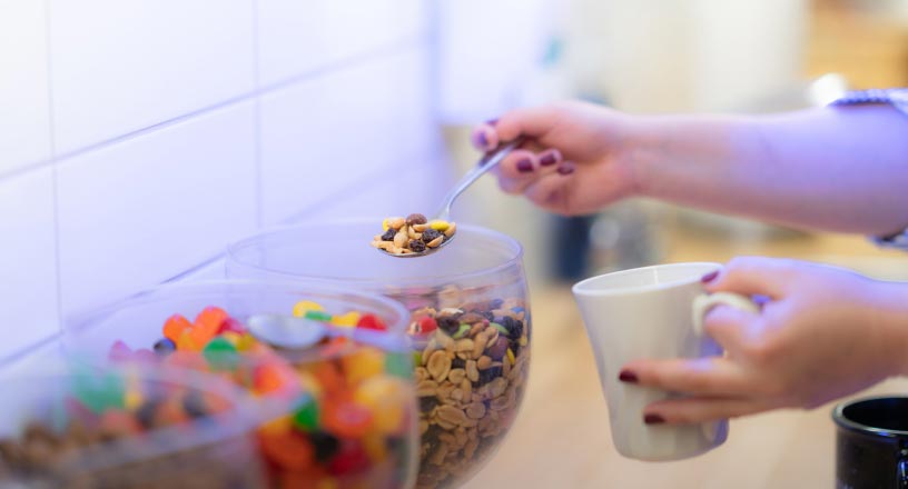 Hands scoop candy out of a container in the REDspace kitchen.