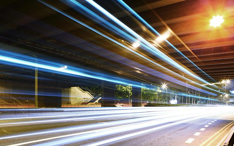 A blur of lights from cars on a street representing speed.