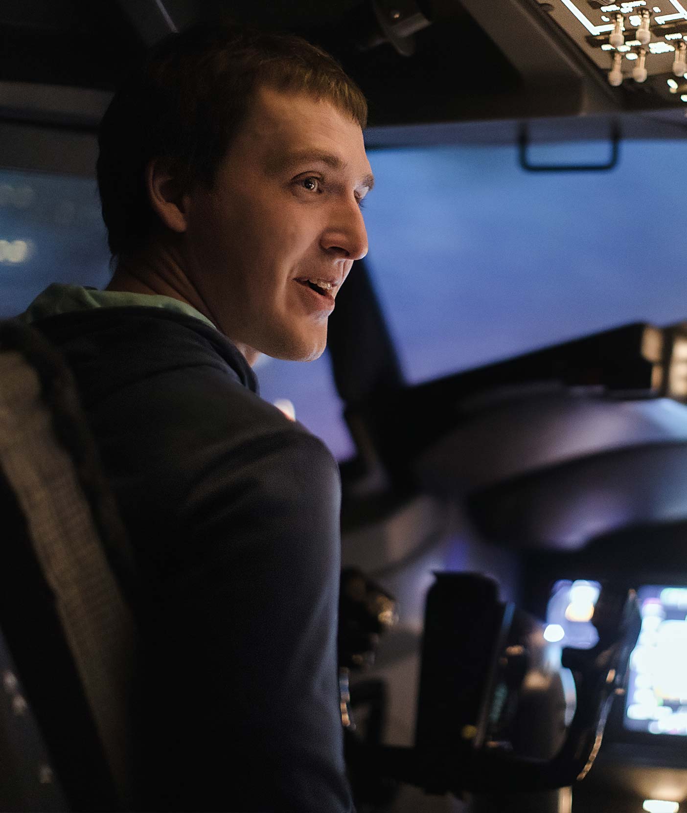 Young man smiles while using a flight simulator.