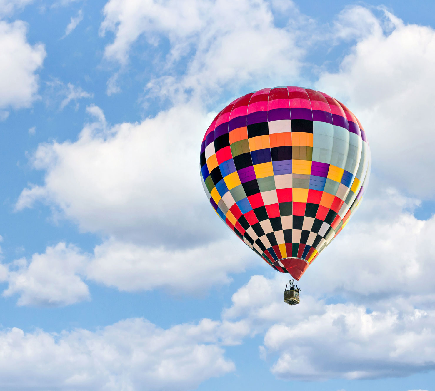 A colorful hot air balloon floats in the sky.